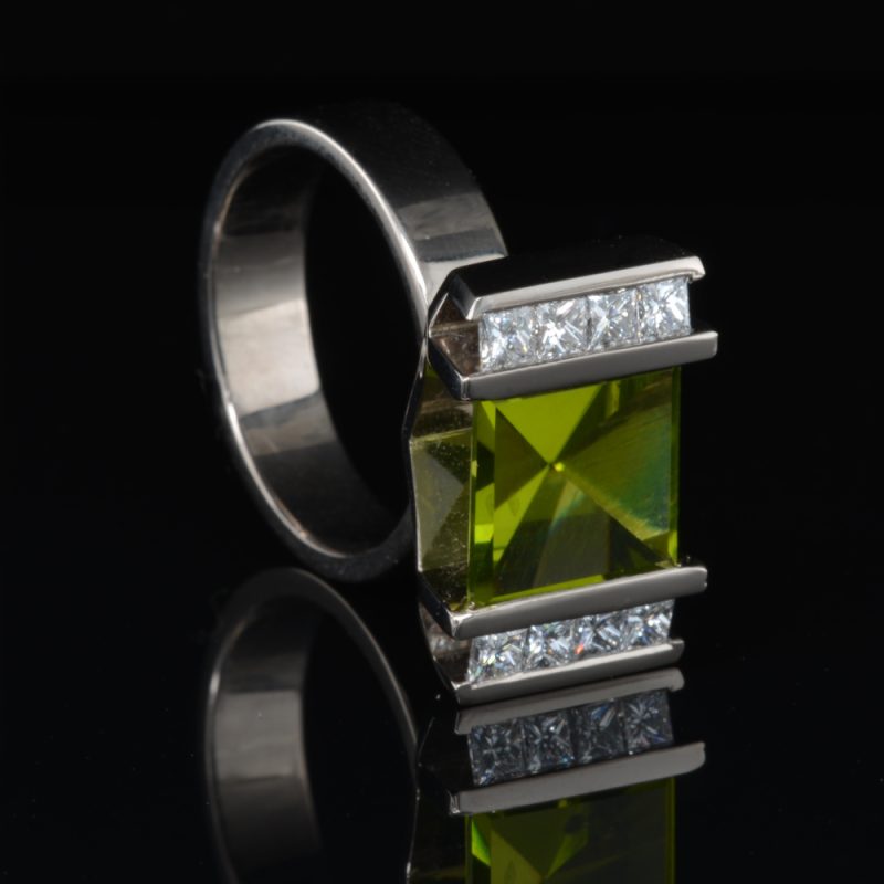 Custom Rudolf Heltzel white gold peridot engagement ring with channel set side diamonds